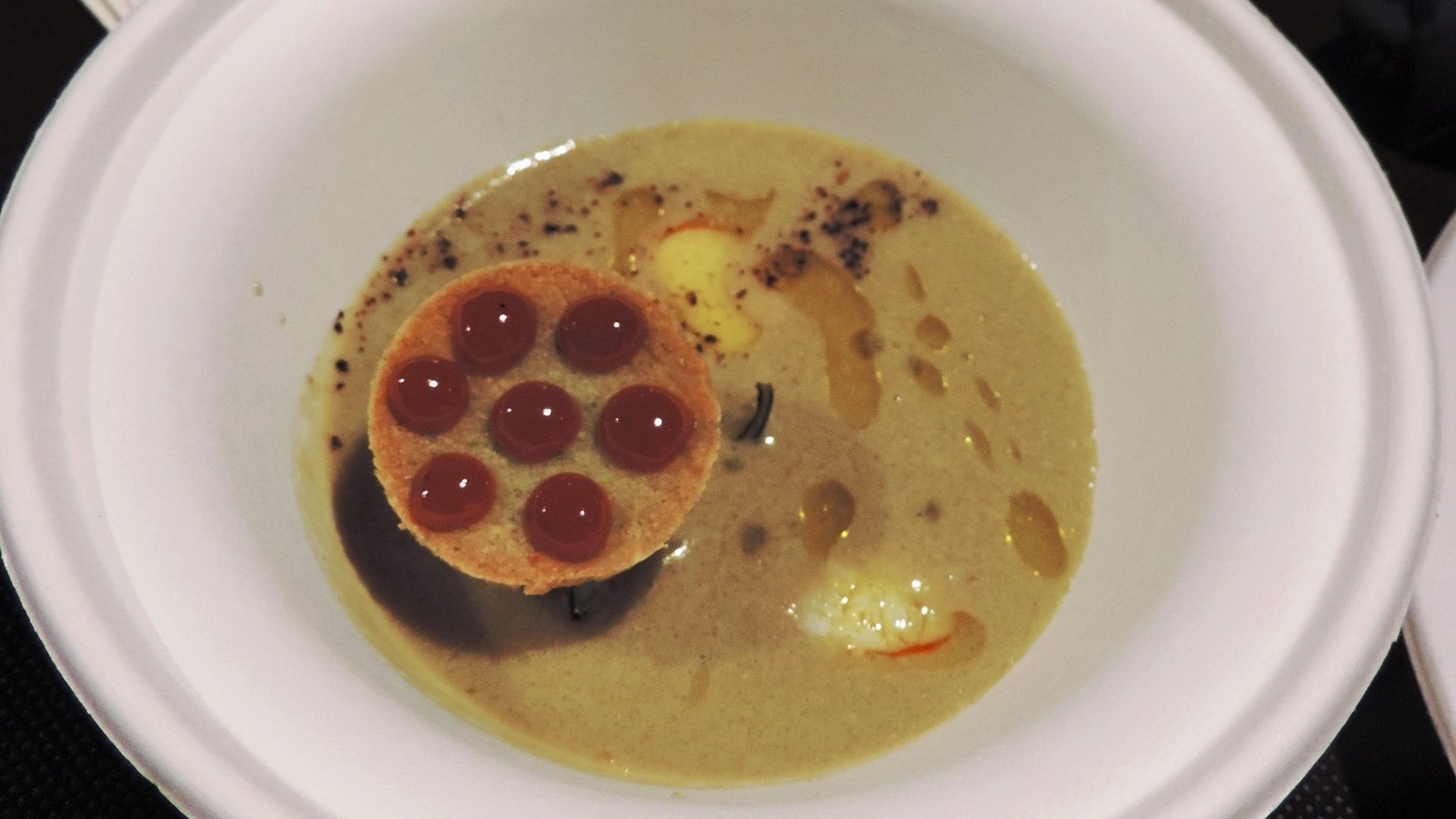 La zuppa di granchi di Anzio al latte di cocco e talli d'aglio, polvere di peperoni arrostiti, crostini di pane al basilico ed erborinato locale. Del ristorante Il Convivio