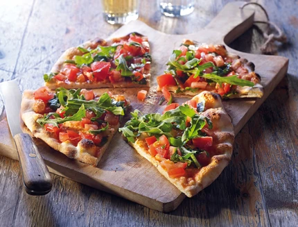 Pizza Pane mit Tomaten & Rucola, in St√ºcke geschnitten auf Holzbrett