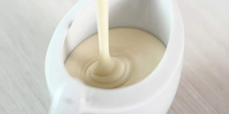 Pouring bechamel white sauce into gravy boat. Making Lasagna Bolognese Series.